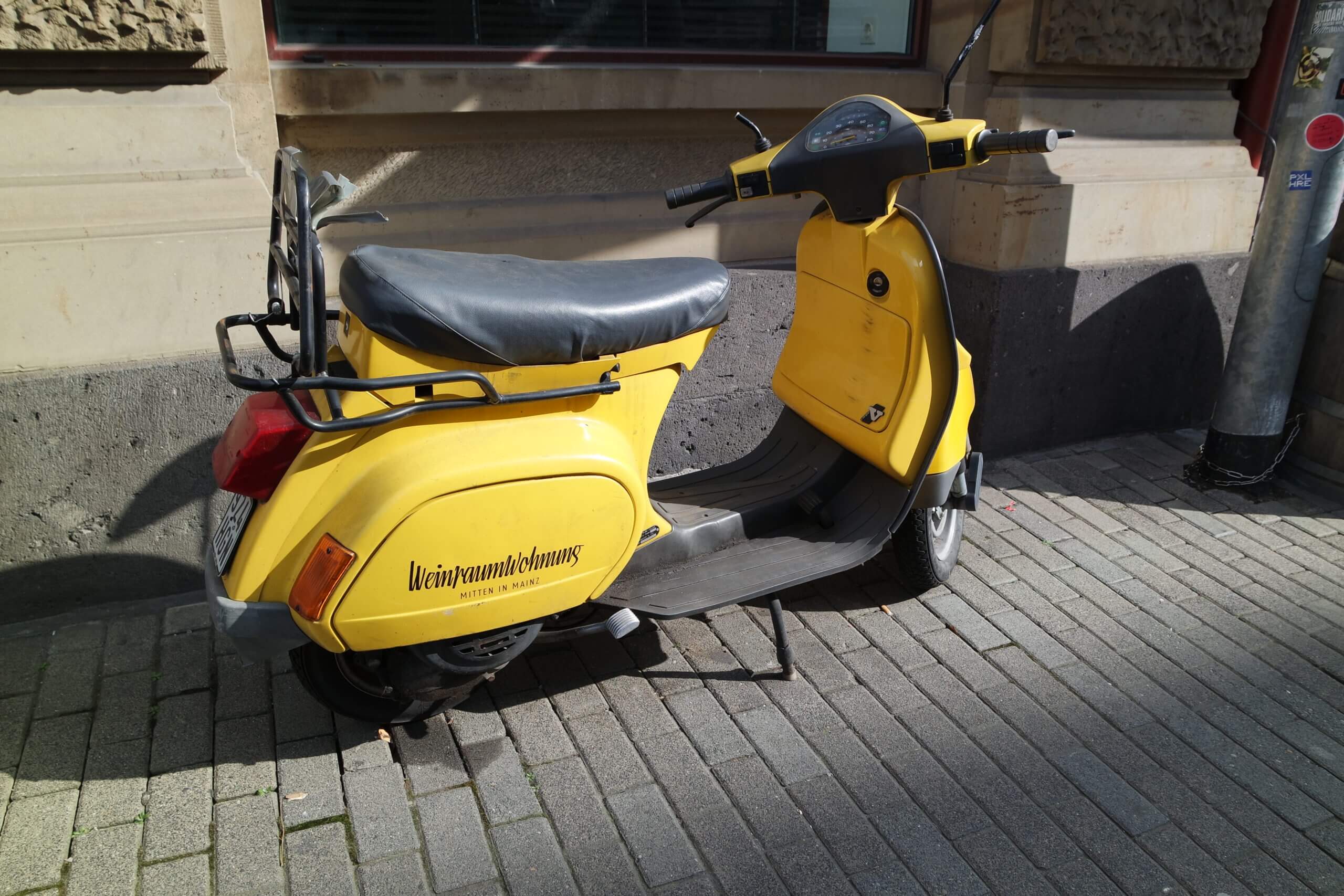 Hingucker: Der gelbe Motorroller vorm Laden.
